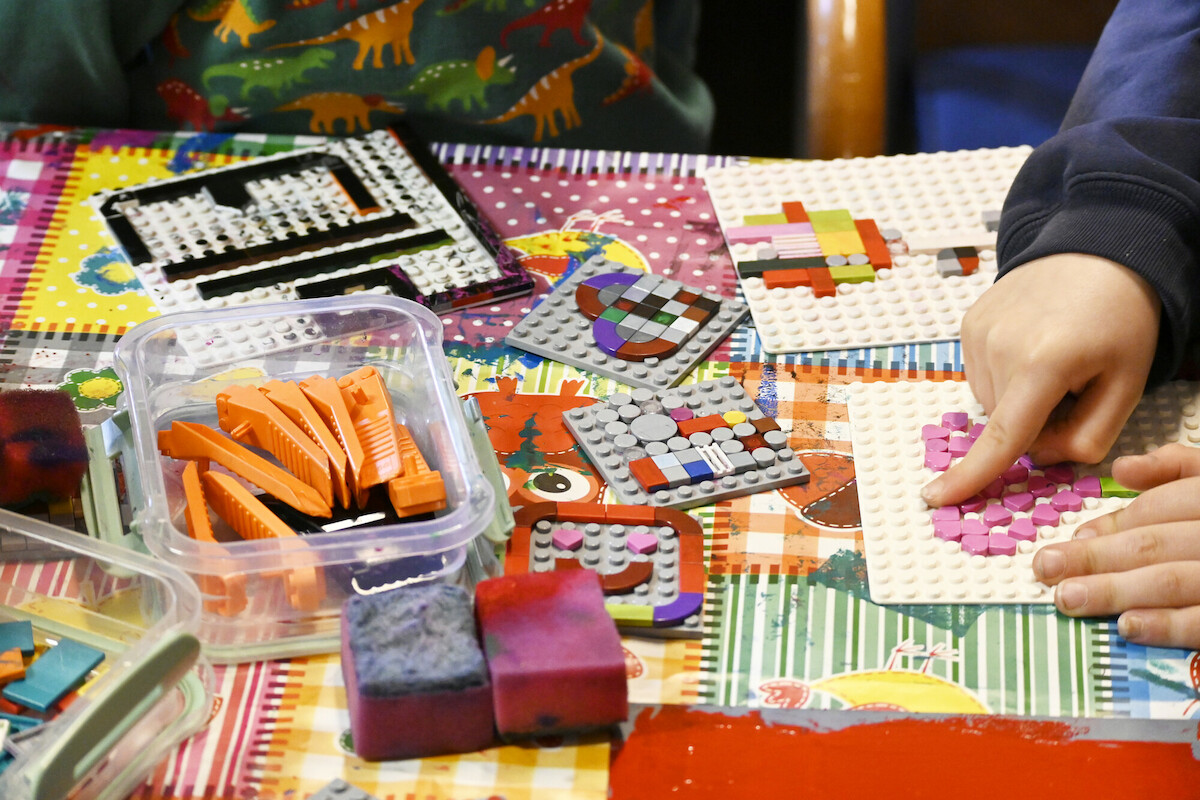 Kinderhände bauen mit Legosteinen