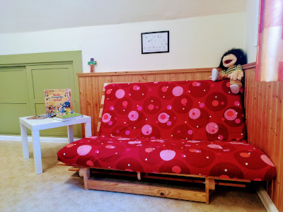 Rotes Sofa mit Tisch im oberen Raum im Anbau der Trinitatiskirche